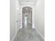Hallway with tile flooring, neutral walls, and arched doorways leading to other rooms in the house at 23823 Waverly Cir, Venice, FL 34293