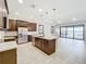 Open kitchen features dark wood cabinetry, stainless steel appliances, and island, flowing into a large living space at 23823 Waverly Cir, Venice, FL 34293