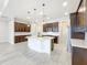 Bright kitchen offers dark cabinets, mosaic backsplash, stainless appliances, and a large center island at 23823 Waverly Cir, Venice, FL 34293