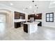 Spacious kitchen boasts dark wood cabinets, stainless steel appliances, and a center island with pendant lighting at 23823 Waverly Cir, Venice, FL 34293