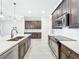 Kitchen with dark cabinets, white countertops, stainless steel appliances, and tile floors at 23823 Waverly Cir, Venice, FL 34293