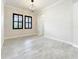 Bright living room with neutral paint, black framed windows, archways, and tile floors at 23823 Waverly Cir, Venice, FL 34293