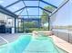Enjoy outdoor living with this screened pool, spa, and kitchen area overlooking beautiful landscaping and lake at 23823 Waverly Cir, Venice, FL 34293