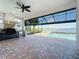 Outdoor living area with a screened-in pool, kitchen, and brick flooring overlooks a serene lake at 23823 Waverly Cir, Venice, FL 34293