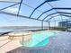 The screened pool area with a spa overlooks the lake and creates a private oasis for outdoor enjoyment at 23823 Waverly Cir, Venice, FL 34293