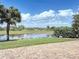 Gorgeous backyard view of a pond with trees and shrubs, brick patio at 23901 Waverly Cir, Venice, FL 34293