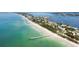 Stunning aerial view showcasing the turquoise water and sandy beach near waterfront property at 3417 Clark Rd # 217, Sarasota, FL 34231