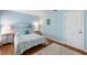 Inviting bedroom with a beautiful blue color scheme, wood floors, and a quaint nightstand at 3417 Clark Rd # 217, Sarasota, FL 34231