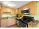 Modern kitchen featuring stainless steel appliances, granite countertops, and wood cabinets at 3417 Clark Rd # 217, Sarasota, FL 34231