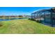 Manicured lawn and screened-in pool near the waterfront provide a calming backyard setting at 3459 Lakewood Blvd, North Port, FL 34287