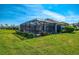 A cozy screened-in pool and lush lawn create a private backyard oasis by the water at 3459 Lakewood Blvd, North Port, FL 34287
