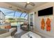 A cozy screened-in lanai with a ceiling fan overlooking the pool and picturesque lake at 3459 Lakewood Blvd, North Port, FL 34287