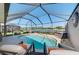 Sparkling pool area with lounge chairs and scenic lake views within screened enclosure at 3459 Lakewood Blvd, North Port, FL 34287