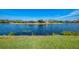 Tranquil waterfront view with lush green grass, creating a serene backdrop for lakeside homes at 3459 Lakewood Blvd, North Port, FL 34287