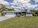 Charming single-story home with a well-manicured lawn and gray exterior and a white two-car garage at 4070 Kincord Ln, North Port, FL 34287