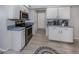 Modern kitchen featuring stainless steel appliances, white cabinets, and wood-look tile flooring at 4070 Kincord Ln, North Port, FL 34287