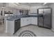 Efficient kitchen with stainless steel appliances, bright white cabinets, and wood-look tile flooring at 4070 Kincord Ln, North Port, FL 34287