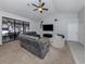 Bright living room with plush carpet, a ceiling fan, and a comfortable gray sectional sofa at 4070 Kincord Ln, North Port, FL 34287