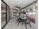 Bright sunroom with tile floors, ceiling fan, and view of the landscaped backyard and outdoor living space at 4070 Kincord Ln, North Port, FL 34287