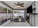 Bright sunroom with tiled floors, ceiling fan, mounted TV, and comfortable seating for relaxing and entertaining at 4070 Kincord Ln, North Port, FL 34287