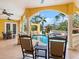 View of the backyard pool and spa area, with yellow stucco walls, columns, and a covered dining space at 416 Baycrest Dr, Venice, FL 34285