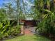 Backyard with lush landscaping, walkway, wooden bench, and decorative features for serene outdoor enjoyment at 416 Baycrest Dr, Venice, FL 34285