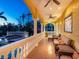 A covered outdoor patio with couches overlooks the pool and garden area with beautiful architecture at dusk at 416 Baycrest Dr, Venice, FL 34285