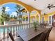Spacious balcony overlooking a pool, featuring elegant columns and comfortable outdoor seating with beautiful tropical views at 416 Baycrest Dr, Venice, FL 34285