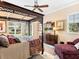 Comfortable bedroom featuring a canopy bed, a sitting area, and multiple windows offering scenic outdoor views at 416 Baycrest Dr, Venice, FL 34285