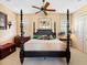 Bedroom with a four poster bed, ceiling fan, neutral walls and carpet and two windows with blinds at 416 Baycrest Dr, Venice, FL 34285