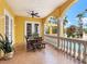 Covered dining area with a wood table, bright yellow stucco walls, and decorative columns overlooking the pool at 416 Baycrest Dr, Venice, FL 34285