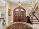 Grand foyer features a stunning staircase, arched doorway, and elegant chandelier at 416 Baycrest Dr, Venice, FL 34285