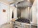 Close-up of stainless steel stove with hood, a tiled backsplash and floor, in this well-equipped kitchen at 416 Baycrest Dr, Venice, FL 34285