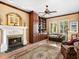 Cozy living room featuring a fireplace, custom built-ins, and a large window providing ample natural light at 416 Baycrest Dr, Venice, FL 34285
