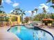 Backyard pool with lounge chairs, a built-in spa, and mature landscaping at 416 Baycrest Dr, Venice, FL 34285
