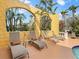 Outdoor patio area with a row of lounge chairs and tropical landscaping at 416 Baycrest Dr, Venice, FL 34285