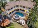 Aerial view of rear exterior showcasing the pool, hot tub, patio, balcony, and lush landscaping at 416 Baycrest Dr, Venice, FL 34285