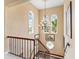 Elegant foyer staircase with a decorative chandelier and bright windows offering scenic views of the outdoors at 416 Baycrest Dr, Venice, FL 34285