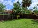 Sprawling backyard featuring a well-manicured lawn, a decorative birdbath, and privacy fencing with lush landscaping at 416 Baycrest Dr, Venice, FL 34285