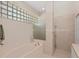 Bright bathroom with large tub, glass block window and glass enclosed shower at 419 Shore Rd, Nokomis, FL 34275