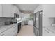 Spacious kitchen featuring stainless steel appliances, gray backsplash, and white cabinets at 419 Shore Rd, Nokomis, FL 34275