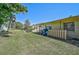 Residential backyard featuring a green lawn with mature trees, shrubs and a partially fenced boundary at 4437 Tippecanoe Trl # 6, Sarasota, FL 34233