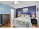 Comfortable main bedroom with a blue accent wall, wood floors, and ensuite bathroom access at 4437 Tippecanoe Trl # 6, Sarasota, FL 34233