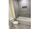 Modern bathroom with grey tiled shower over the bathtub, and a toilet next to it at 4595 Horseshoe Ave, North Port, FL 34286