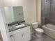 Bathroom featuring granite counters, a white vanity, and a gray tiled shower-tub combination at 4595 Horseshoe Ave, North Port, FL 34286