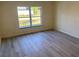 Cozy bedroom with natural light, wood-style flooring, and a pleasant view of the outdoors at 4595 Horseshoe Ave, North Port, FL 34286