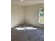 Bright bedroom featuring light gray floors and a window overlooking the yard at 4595 Horseshoe Ave, North Port, FL 34286