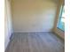 Bright bedroom featuring light gray floors, base trim, and a window that provides ample natural light at 4595 Horseshoe Ave, North Port, FL 34286