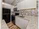 Modern kitchen featuring white cabinets, granite countertops, black appliances, and modern backsplash at 500 N Jefferson Ave # A3, Sarasota, FL 34237