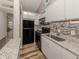 Modern kitchen featuring white cabinets, granite countertops, black appliances, and sleek design at 500 N Jefferson Ave # A3, Sarasota, FL 34237